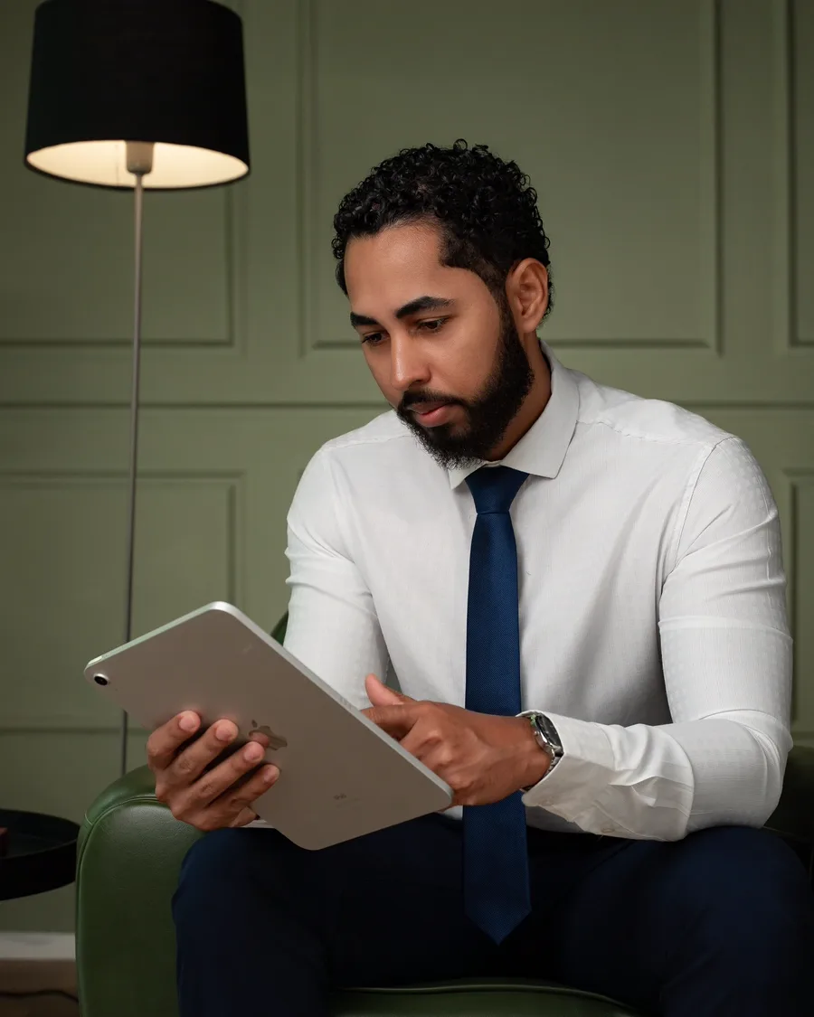 Vitor Vieira sentado, lendo em um tablet
